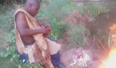 Khokhovula beating the drum (Ngoma) in front of the fire.
