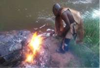 Khokhovula is turning and burning the chicken after a heavy and long dance with the ancestors